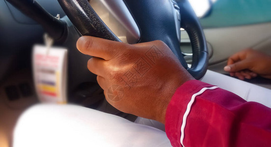 男人的手放在汽车驾驶的方向盘上保持一只手休闲驾驶图片