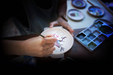 专业女陶工在车间工作室检查带把手的油漆陶瓷手工制作小型企业手工图片