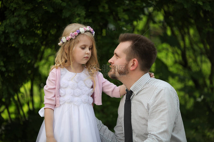 白色礼服和花圈的小伤心女孩和她的父亲爸让他的小女儿开心起来爸的图片