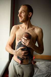 一位父亲把他刚出生的儿子抱在怀里图片