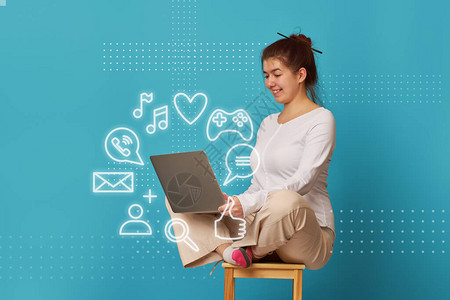女人正坐在带笔记本电脑的椅子上的莲花位置平衡在家工作在线业务或自图片