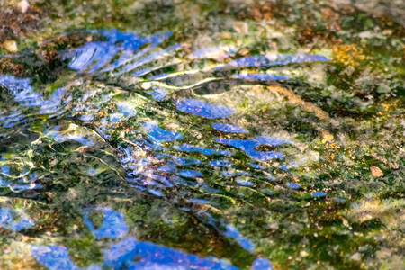 水晶般清澈的小溪水中柔滑的涟漪背景图片