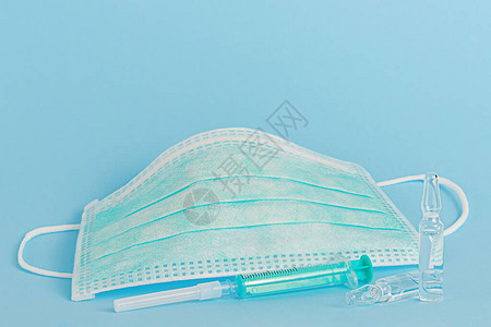 蓝色背景的保护医疗面具疫苗胶囊和图片