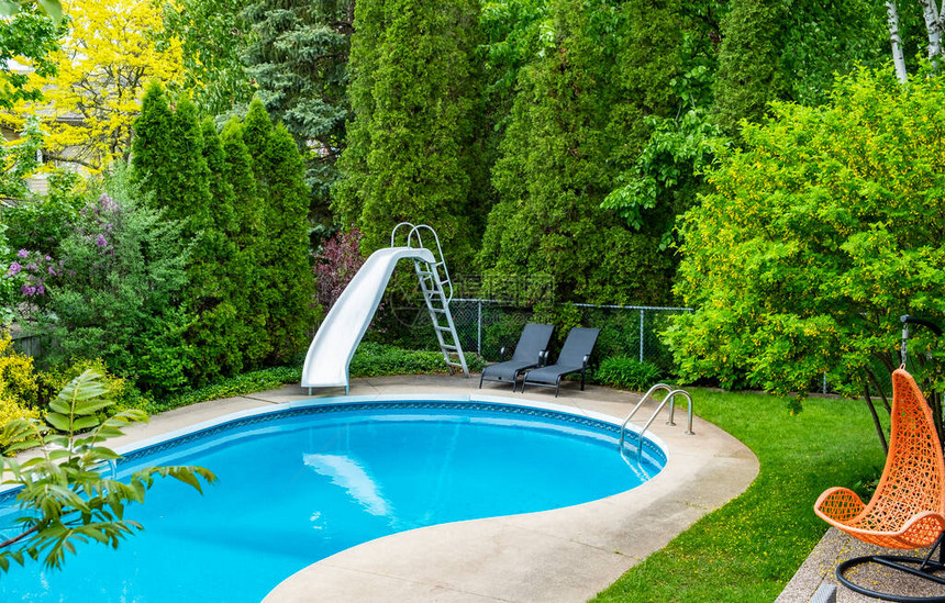 带水滑梯的后院游泳池图片