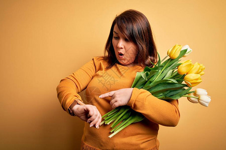 漂亮的大码女人拿着浪漫的天然郁金香花束图片