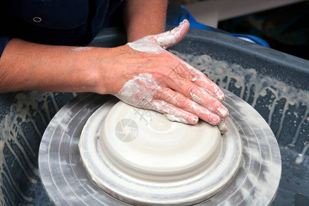 一位女士陶瓷艺术家在她家的陶艺工作室工作图片