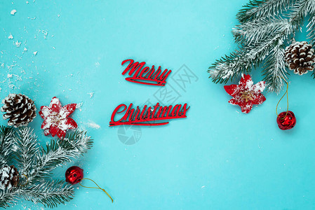 圣诞快乐背景与雪枞树和松果在蓝色背景图片