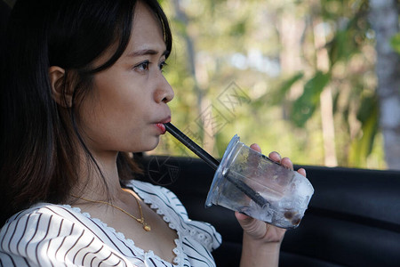 亚洲女在车里喝水图片