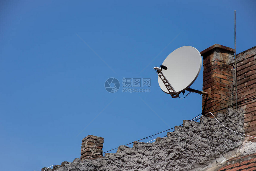 老式屋顶瓦片上的卫星电视天线图片