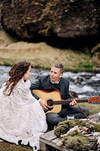 结婚夫妇坐在山河的岸边图片