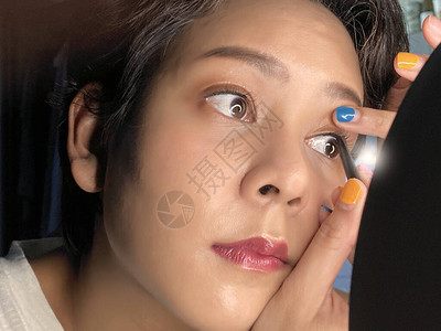 亚洲女人坐在镜子前化妆图片