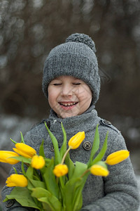 有黄色郁金香的男孩自然背景男孩微笑着图片