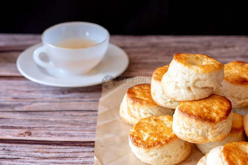 特写一组新鲜美味可口的传统英国烤饼和一杯茶在木图片