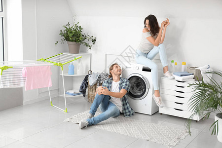 快乐的年轻夫妇在家洗衣服图片