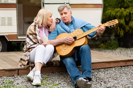 退休夫妇带着声响吉他在露营地的汽车屋图片