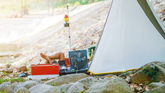 男人在露营帐篷和装备配件附近躺着放松图片