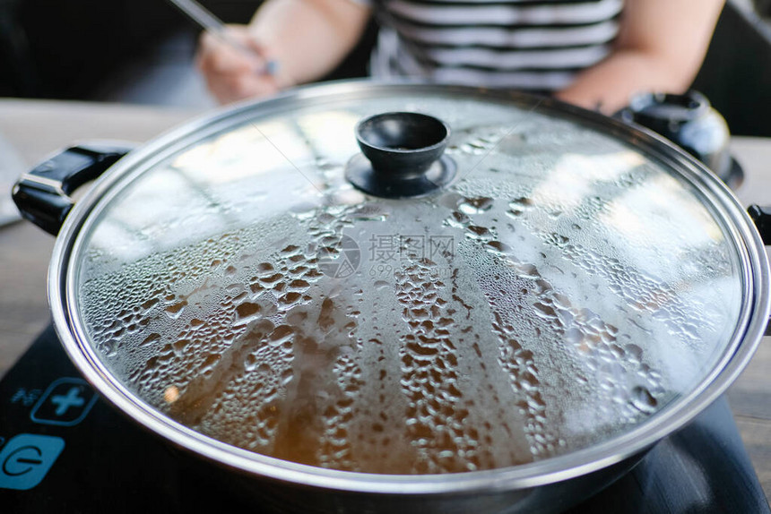 近距离观察火锅并盖上热水蒸汽涮锅是一种牛肉在火锅中的牛肉薄片和水煮的蔬菜泰国最图片