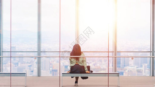 女游客的后视镜坐在窗玻璃上方阳光照耀着美丽的建筑城市景色上图片