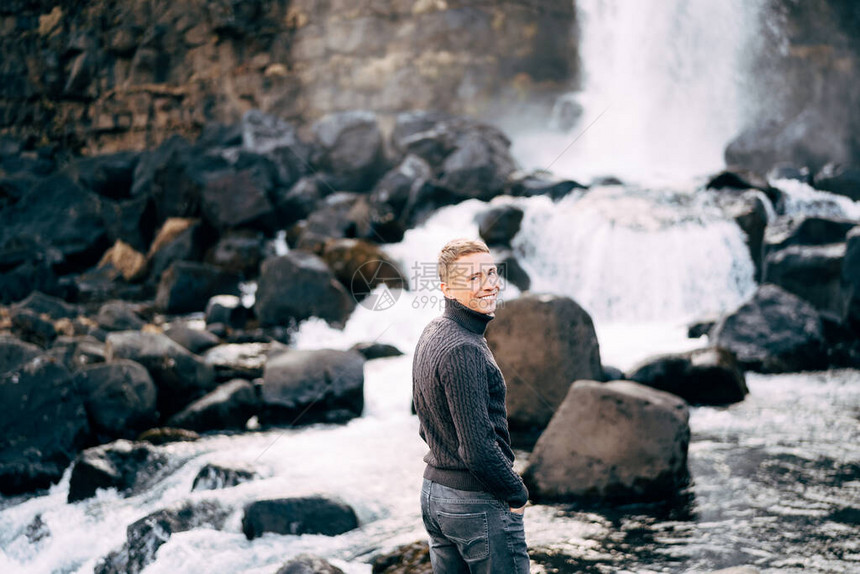 身穿黑毛衣的男子站在冰岛锡杜兰州廷格维尔公园EhsaarurfosFallsEhsarauRiverEhsaro河图片