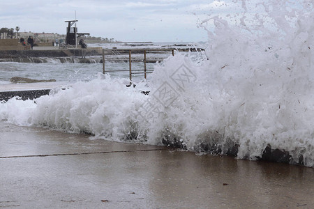 伴随着强风而来的巨浪冲击着海岸的墙壁图片