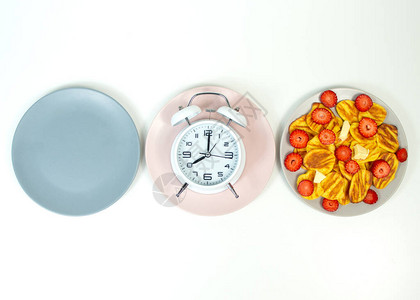 间歇禁食概念与空的彩色盘子时间饮食控制或图片