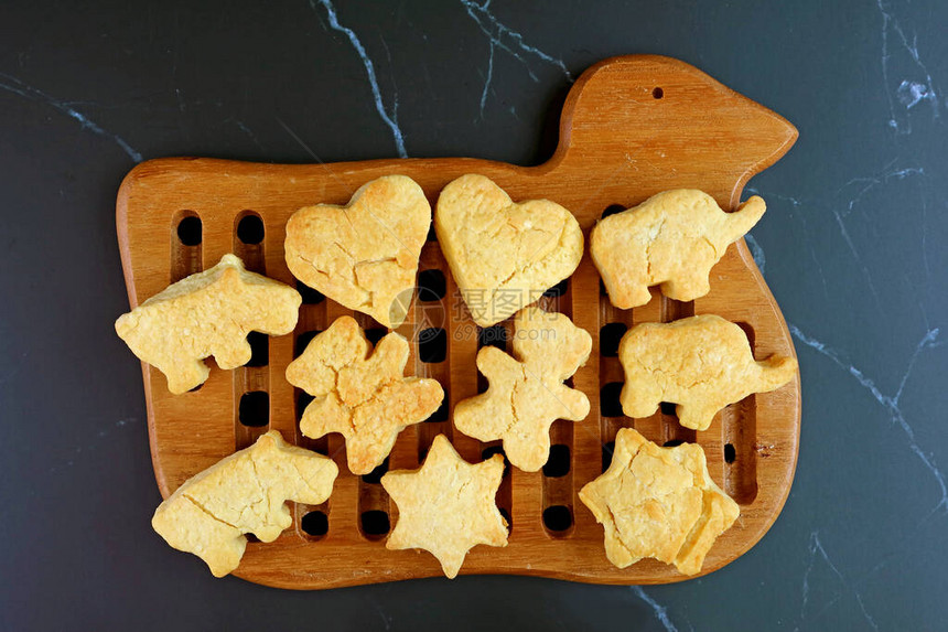 刚烤过的自制黄油饼干在木质面包板上被冷图片