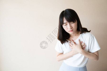 在白色背景下患有胸痛的年轻女子胸痛的原因包括心脏病发作心绞痛心包炎肺栓塞胃灼热胃食管反流病或肌肉劳图片