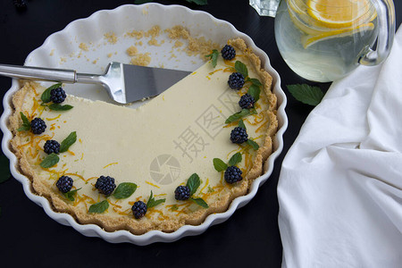 白色陶瓷烤盘中的自制柠檬芝士蛋糕白色盘子上的柠檬芝士蛋图片