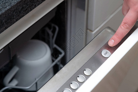 关闭厨房洗碗机上的手指按下启动按钮图片