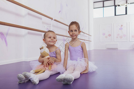 迷人的小芭蕾舞女孩和她可爱的妹在芭蕾舞学校锻炼后休息图片