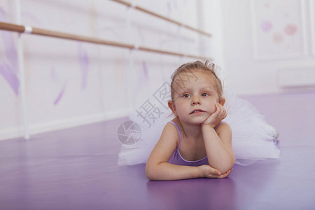 小可爱的芭蕾舞女孩躺在芭蕾舞学校的地板上图片