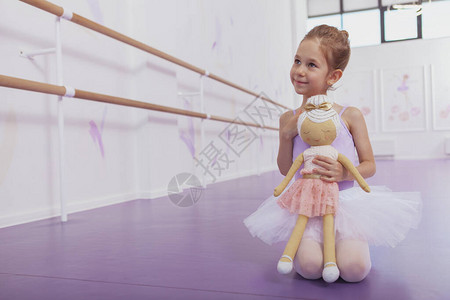 迷人的年轻芭蕾舞女孩坐在芭蕾舞学校的地板上图片