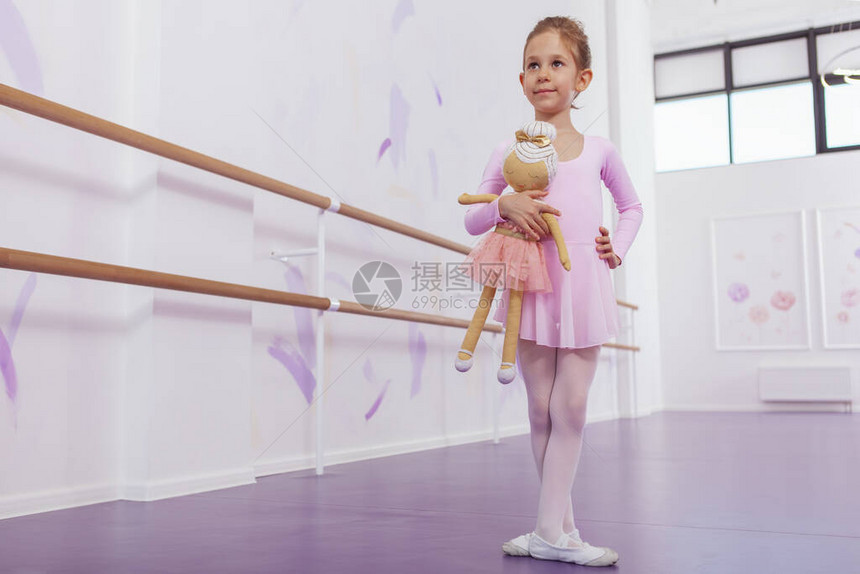 一个可爱的芭蕾舞小女孩在芭蕾舞学校优雅地摆姿势的全长照片图片