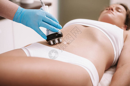 女人在美容诊所的腹部皮肤上享受射频提升手术图片
