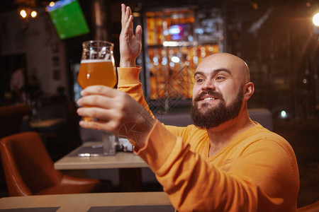 兴奋的大胡子男人称赞他的啤酒快乐的男人满怀爱意地看着他图片