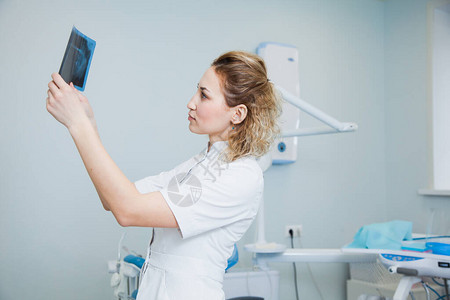 女医生牙医检查人类颌骨的X射线专业口腔科医生在诊所办公室检查牙科图片
