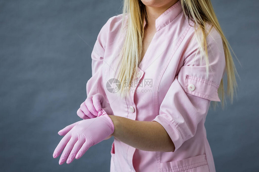 医生戴上粉红色的防护手套图片