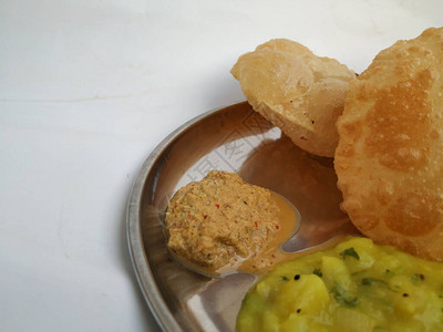 油炸的Poori或Puri配以辣土豆洋葱咖喱和椰子酱它是一种无酵饼图片