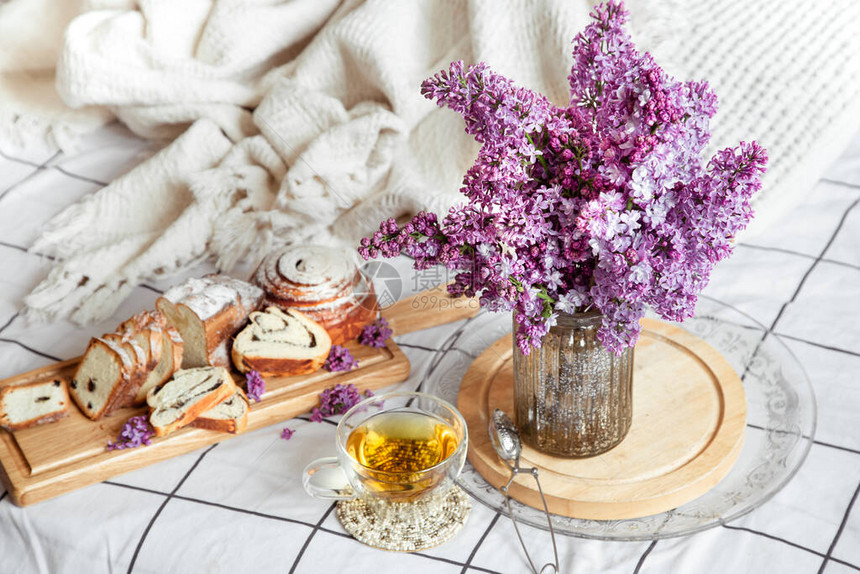 早餐或早午餐在床上享用糕点和茶花瓶里的丁香花浪漫和假期母图片