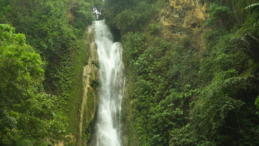 丛林瀑布在被绿色植被包围的热带森林中Mantayupan瀑布在山地丛林中图片