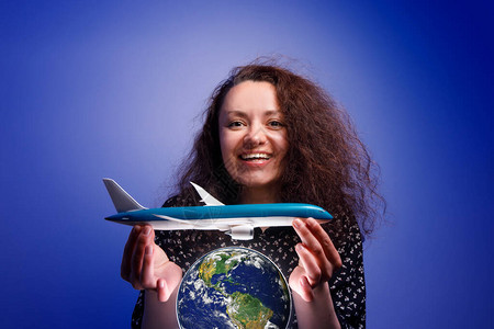 她怀里抱着一个飞机模型在地球上空的女孩航空公图片