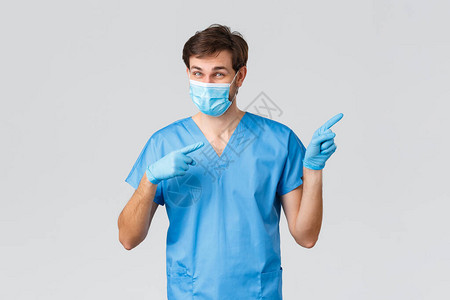 热心的医生戴着医用口罩手套和蓝色护士或外科医生擦洗手指图片