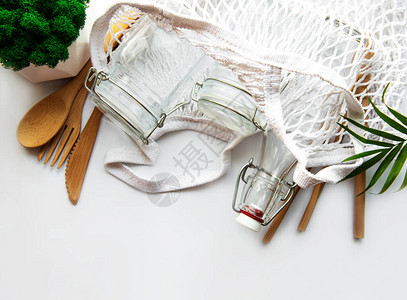 棉袋带可重复使用玻璃罐的网袋白色背景的竹子和木制餐具图片