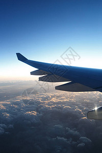 日落时在云层上方的飞机翼图片