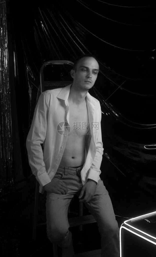 年轻英俊的男人穿着解开的白衬衫的画像霓虹色房间90年代复古风格男附近的图片