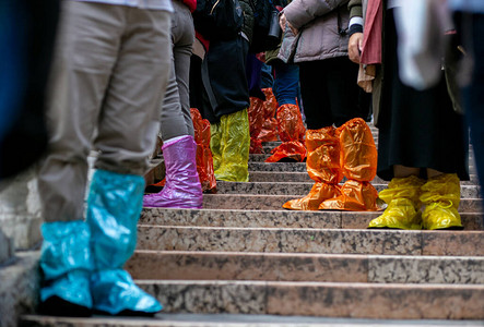在威尼斯的洪涝季节游客穿着亮鞋罩图片