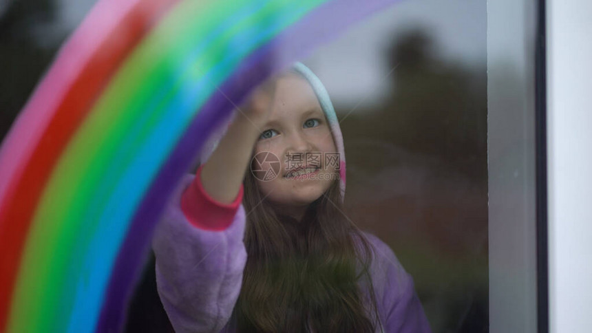 穿着睡衣的女孩在家里的窗户上画彩虹我从窗图片