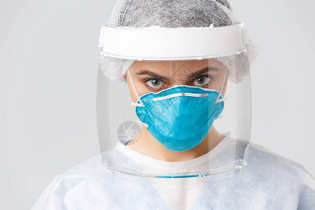 封闭身着个人防护服呼吸器和面罩的严肃而坚定的医生或护士图片