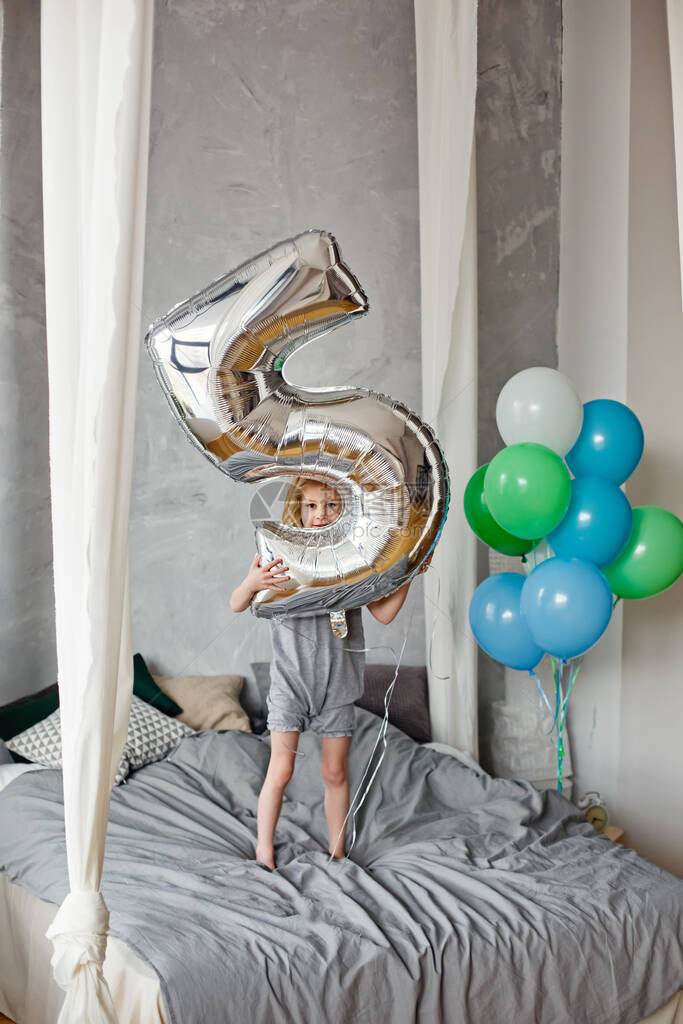 一个小女孩站在卧室里拿着气球一个带着气球过生日的孩子童年庆祝和儿图片