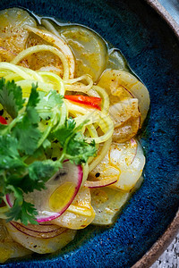 海扇贝鱼片配腌制绿色欧芹洋葱在蓝盘上新鲜的鞑靼鱼图片